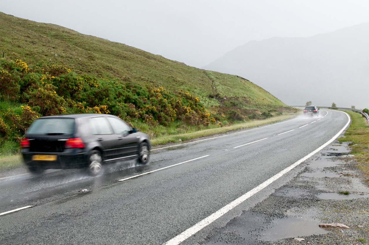 image of a car driving on a wet road