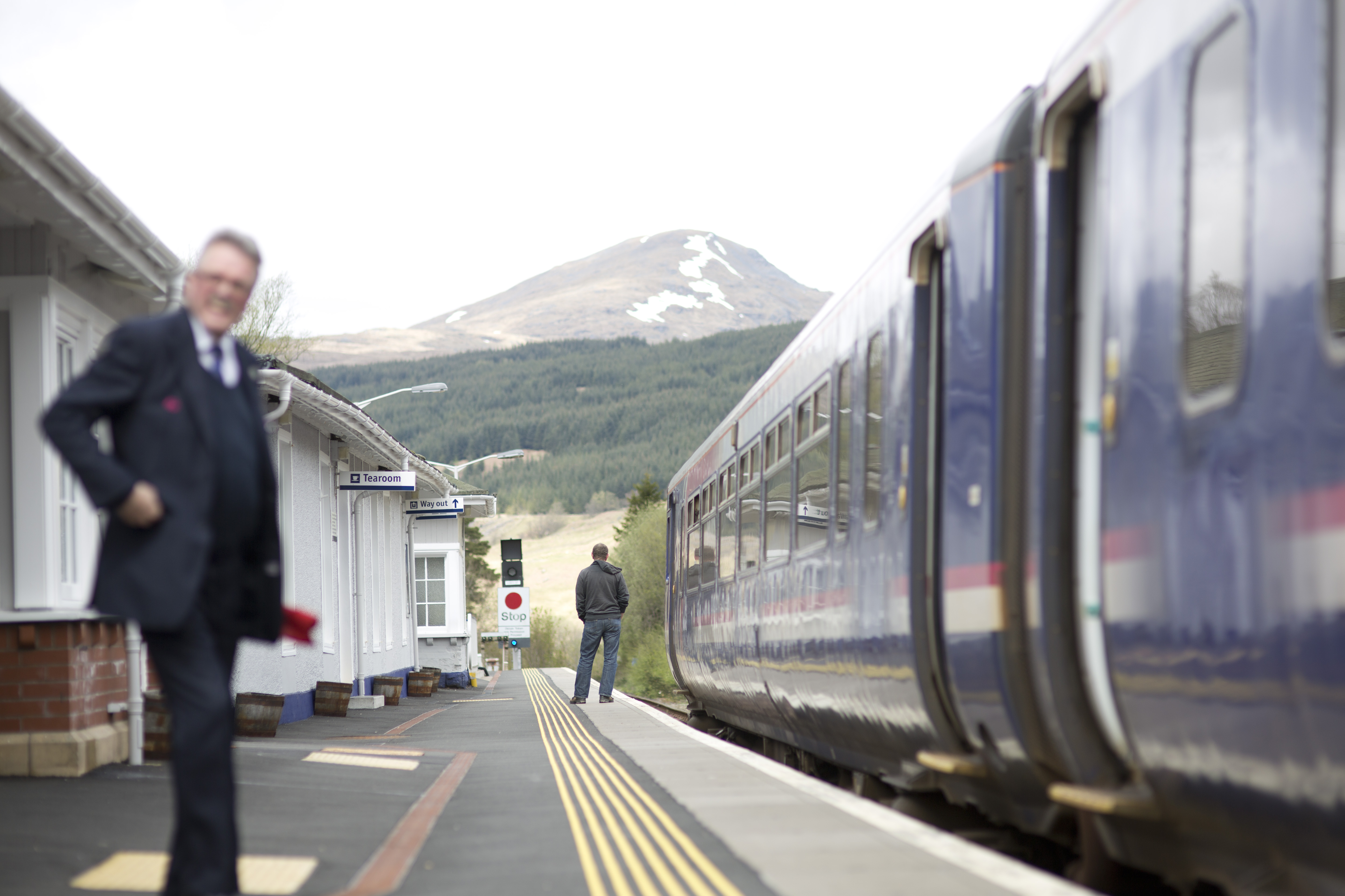 Train in the Scottish Highlands with conductor at the station