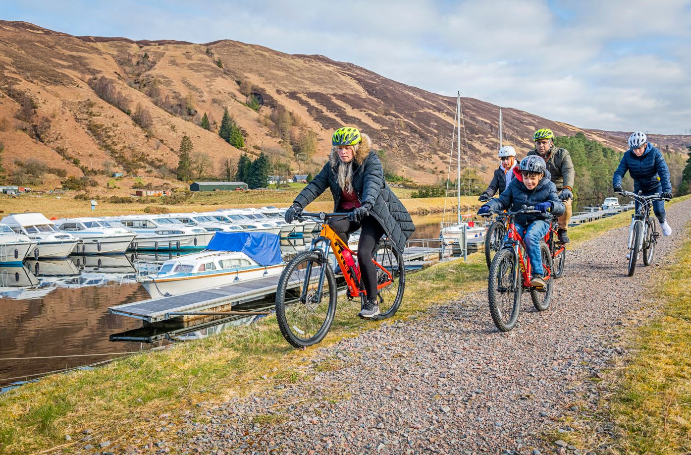 Family cycling past a loch