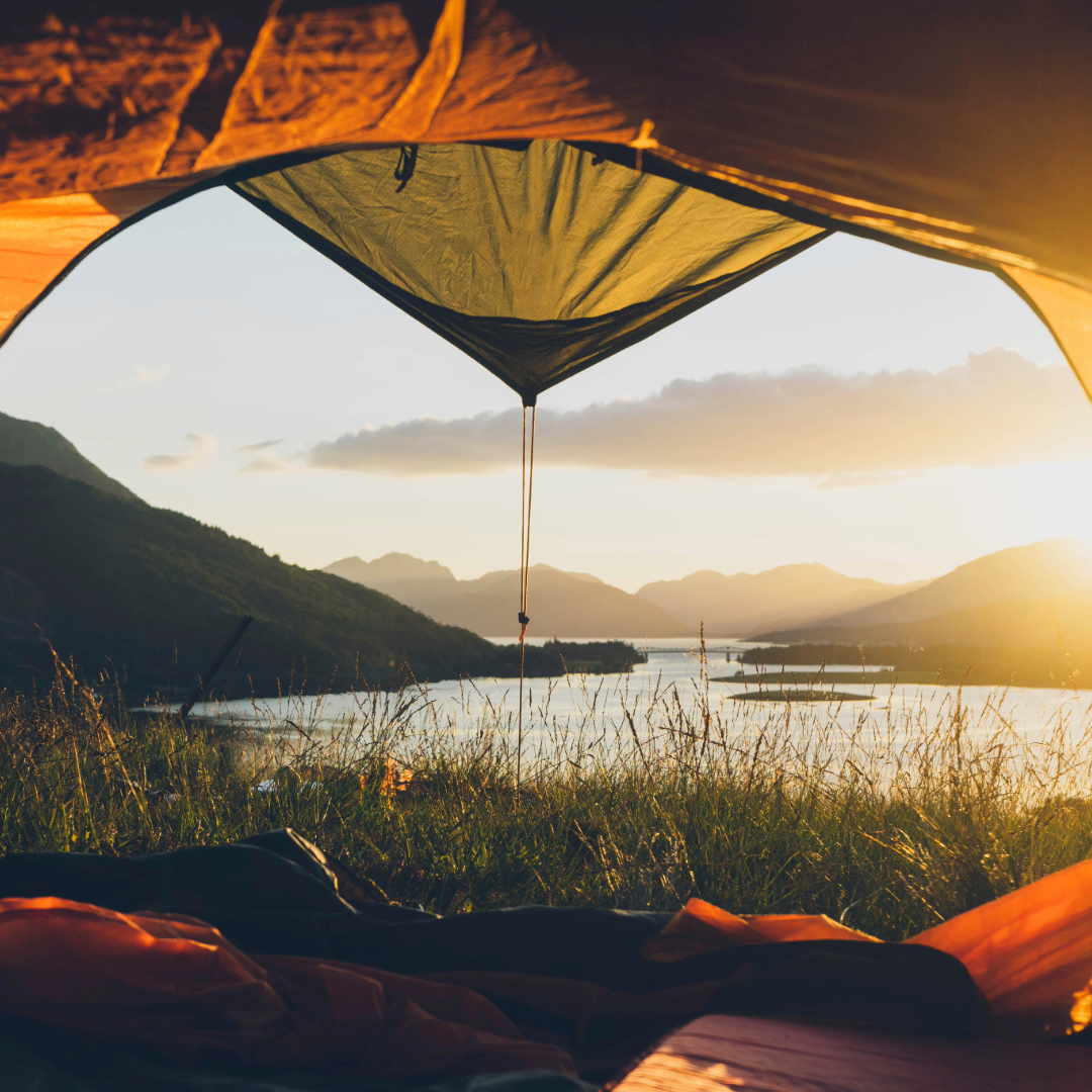 A photo from inside a tent looking onto a loch in Scotland. 