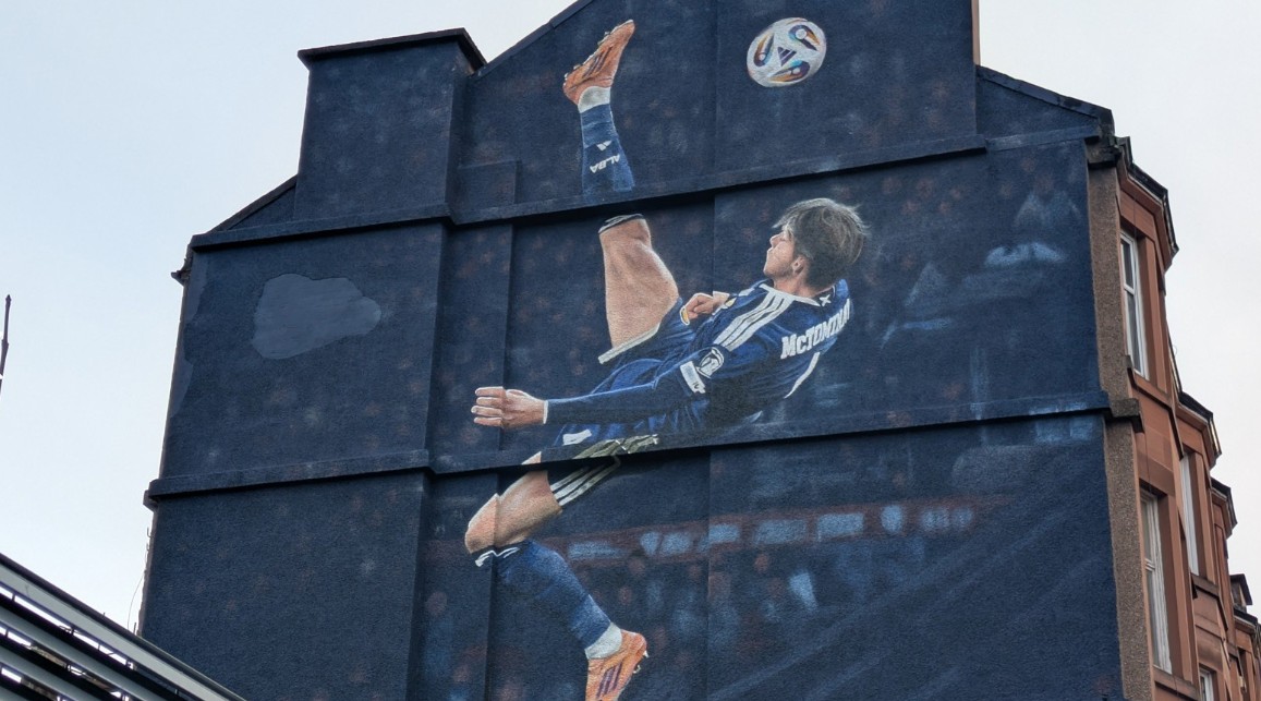 Mural on building of footballer kicking football